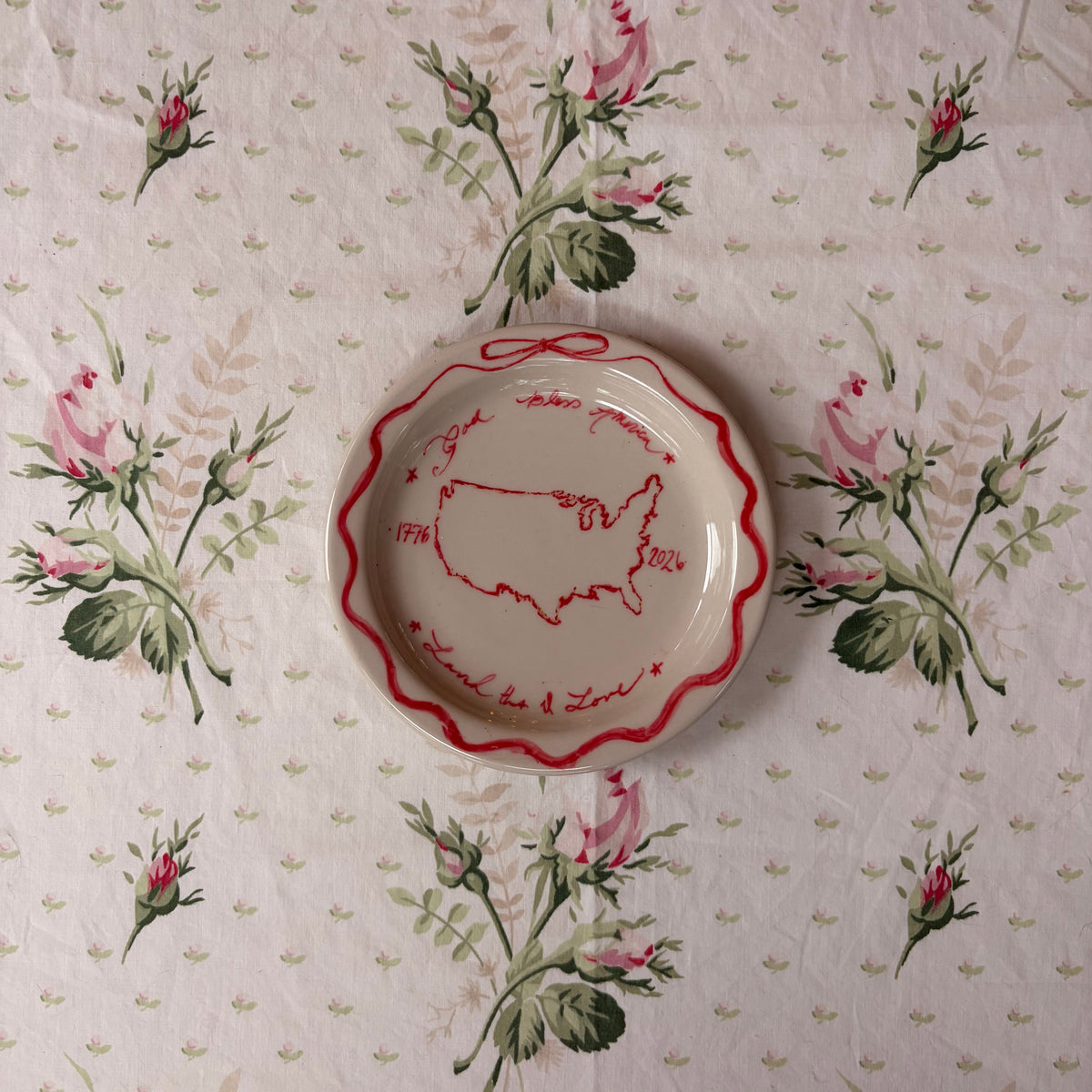 Red whimsical dainty God Bless America, Land that I Love handwriting painted with 1776 2026 framed with a red bow to celebrate America 250