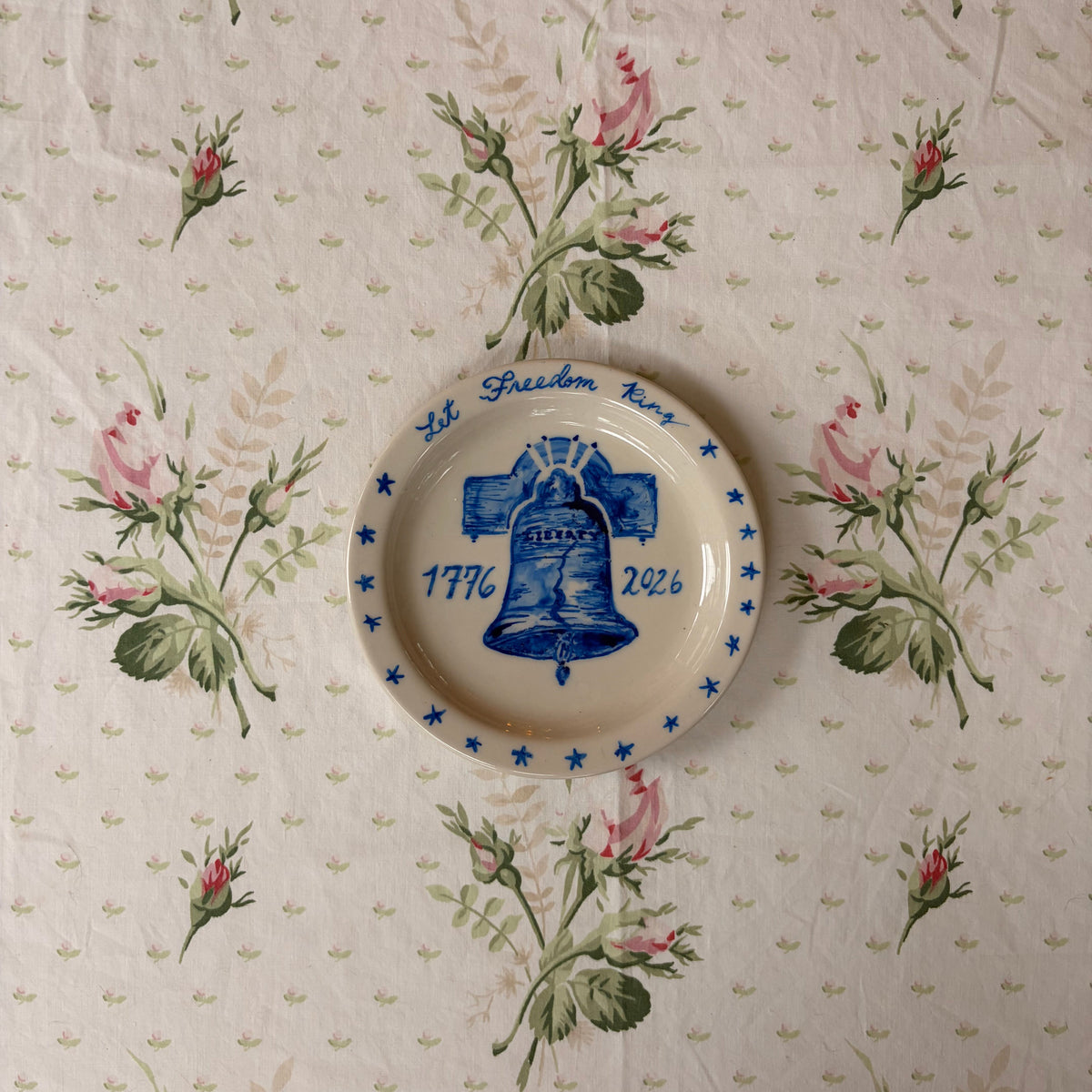 blue hand painted Liberty Bell with 1776 2026 with Let Freedom Ring handwriting painted with blue star border on small ivory plate