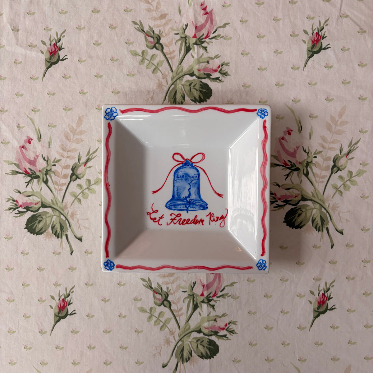 blue and red Let Freedom Ring cursive hand painted with Liberty Bell with red ribbon bow with flower border