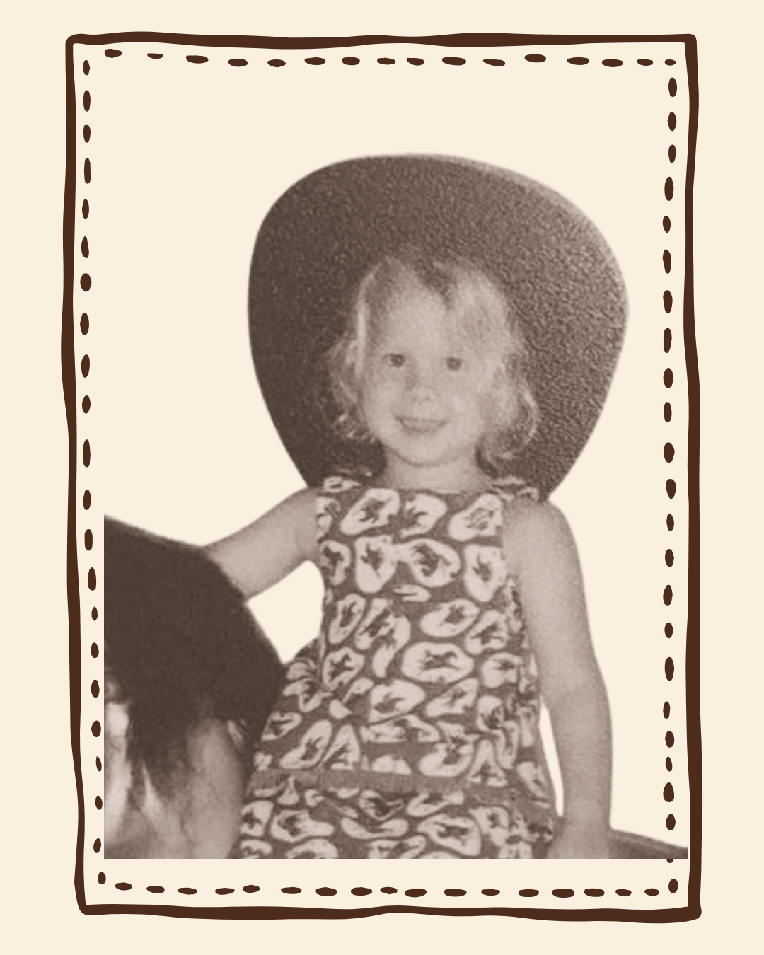 A vintage-style black and white photograph of a young child wearing a wide-brimmed hat and a patterned dress, framed by a stitched-dot border on a cream background.