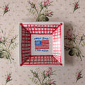 an American Flag with Old Glory cursive hand writing painted on with 1776 2026 in red and blue paint framed in a red checkered border on small white square dish