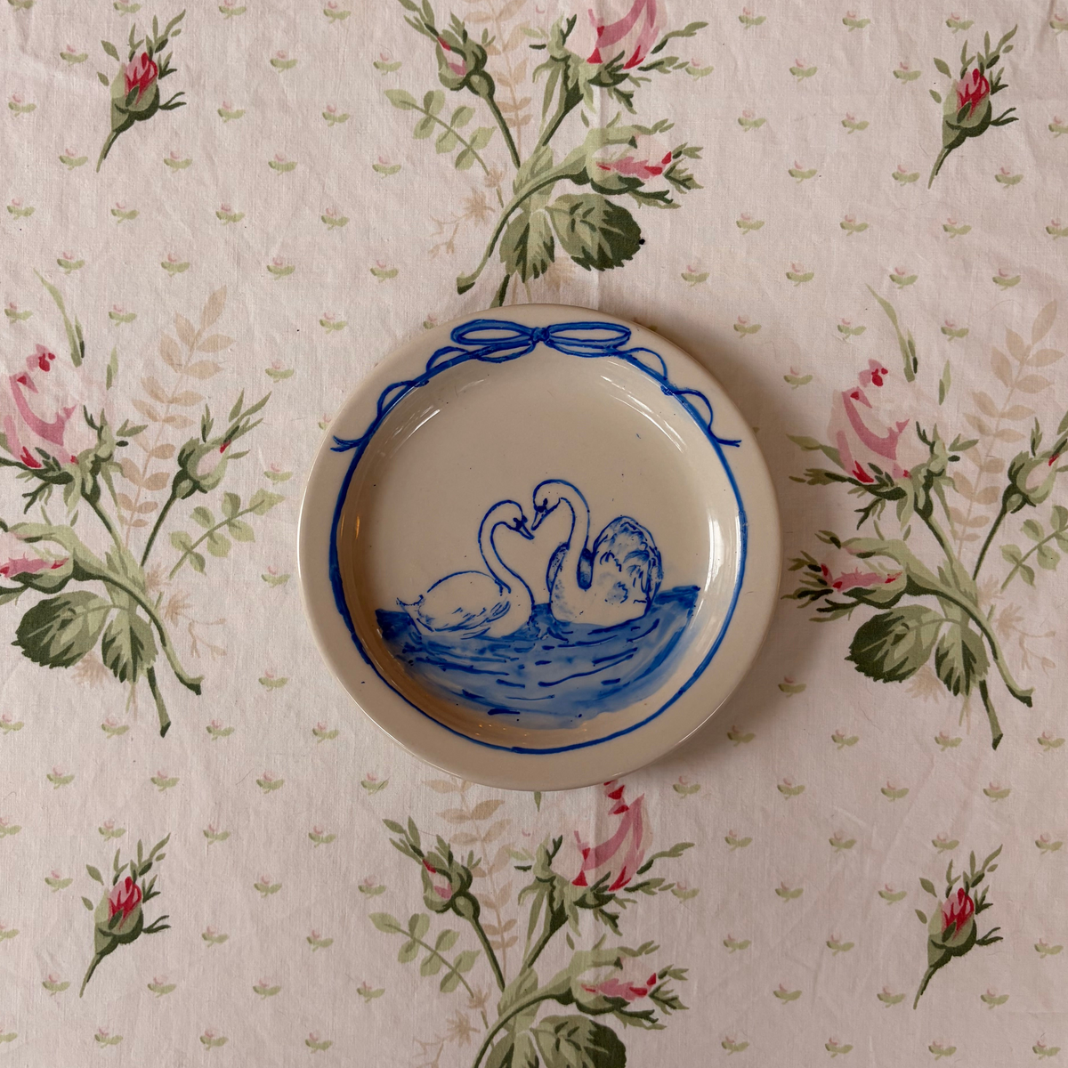 hand painted blue wans with dainty ribbon on ivory small plate
